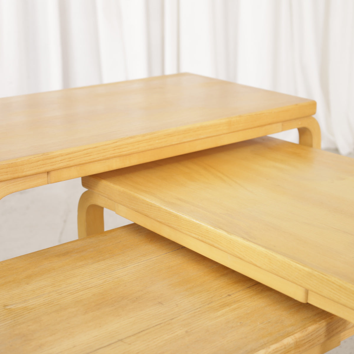 Alvar Aalto nesting tables for Artek, patinated wooden surfaces and bent legs