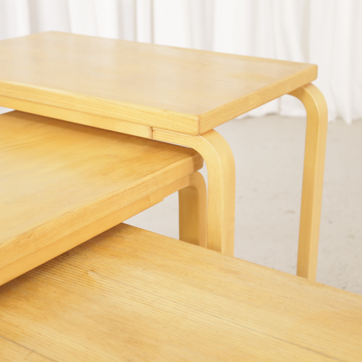 Alvar Aalto nesting tables for Artek, patinated wooden surfaces and bent legs