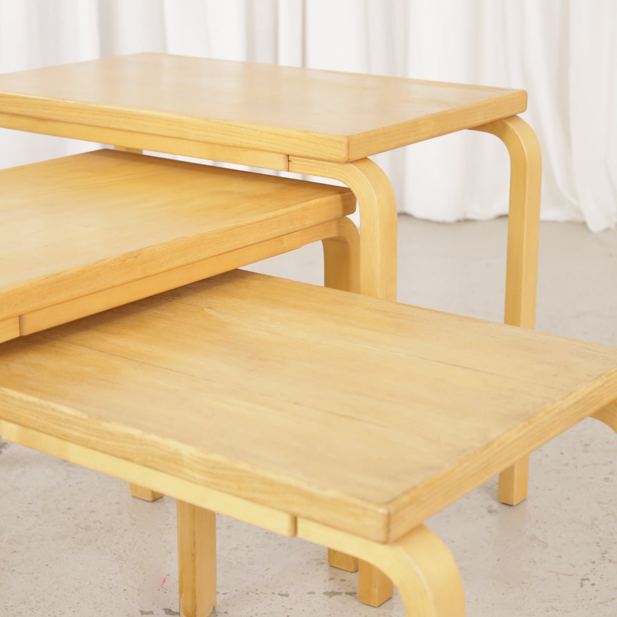 Alvar Aalto nesting tables for Artek, patinated wooden surfaces and bent legs