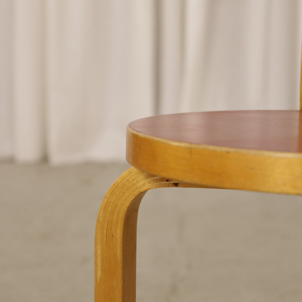Alvar Aalto Chair 65 in Birch and Red Linoleum for Artek, close-up of red linoleum seat edge and birch L-leg