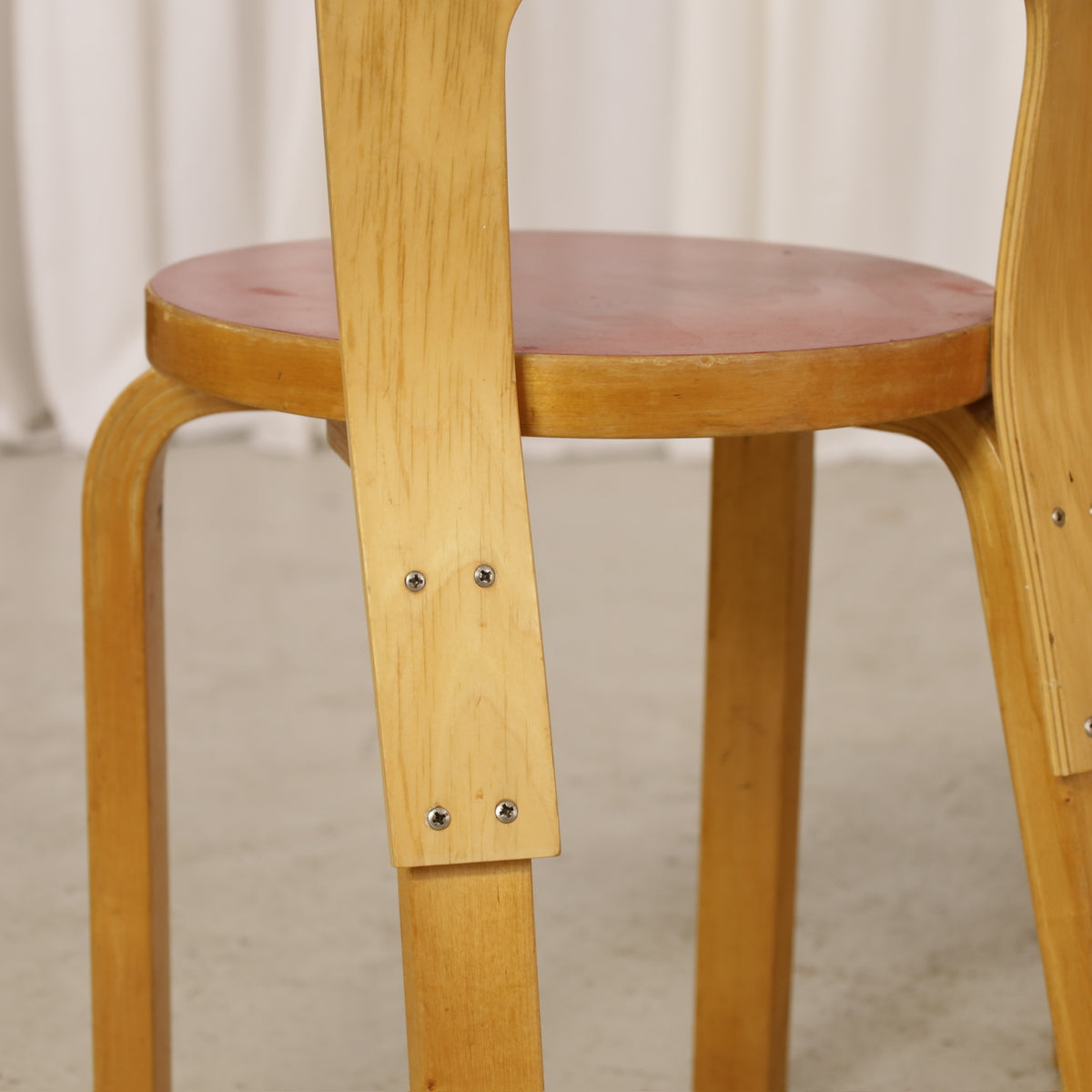 Alvar Aalto Chair 65 in Birch and Red Linoleum for Artek, close-up of replacement screws in Chair 65 birch backrest