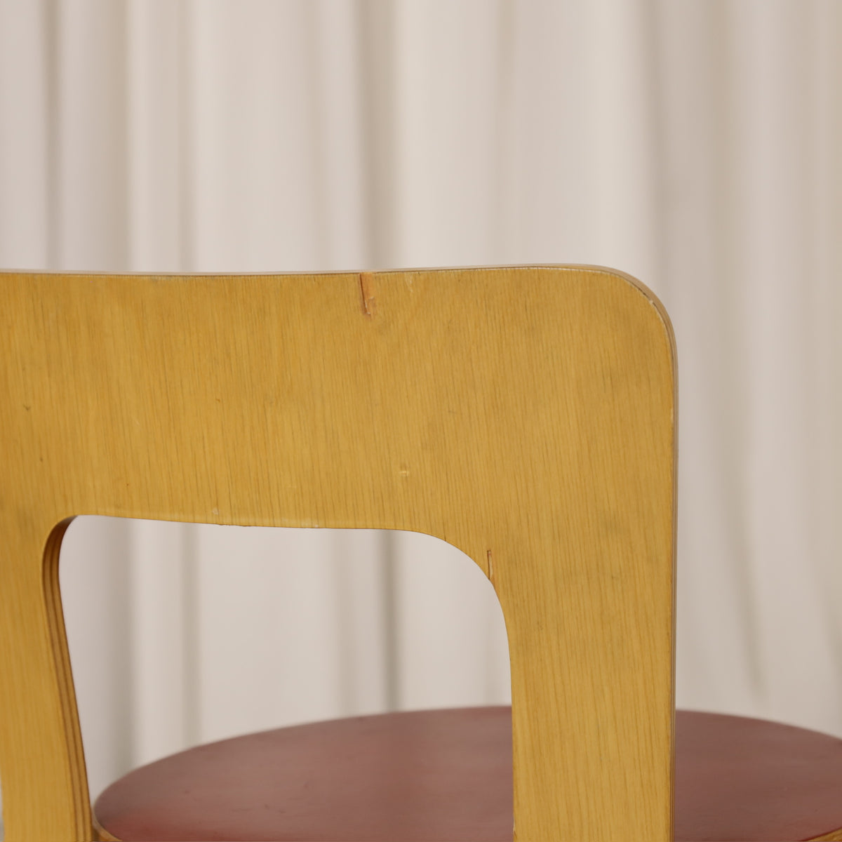 Alvar Aalto Chair 65 in Birch and Red Linoleum for Artek, close-up of small veneer damage on Chair 65 backrest