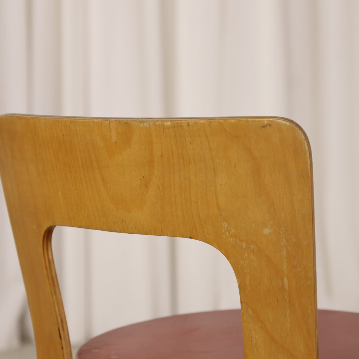 Alvar Aalto Chair 65 in Birch and Red Linoleum for Artek, close-up of minor veneer damage along Chair 65 backrest edge