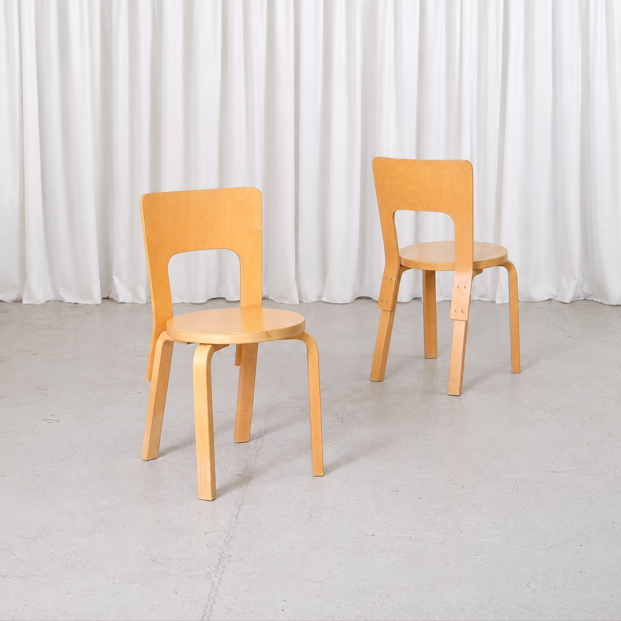 Pair of vintage Artek Chair 66 chairs by Alvar Aalto in natural birch, angled view