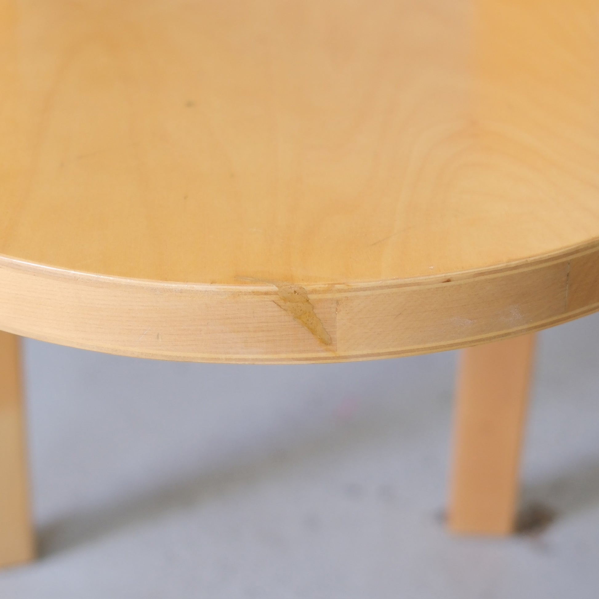 Close-up of a repaired area on the seat edge of a vintage Artek Chair 66