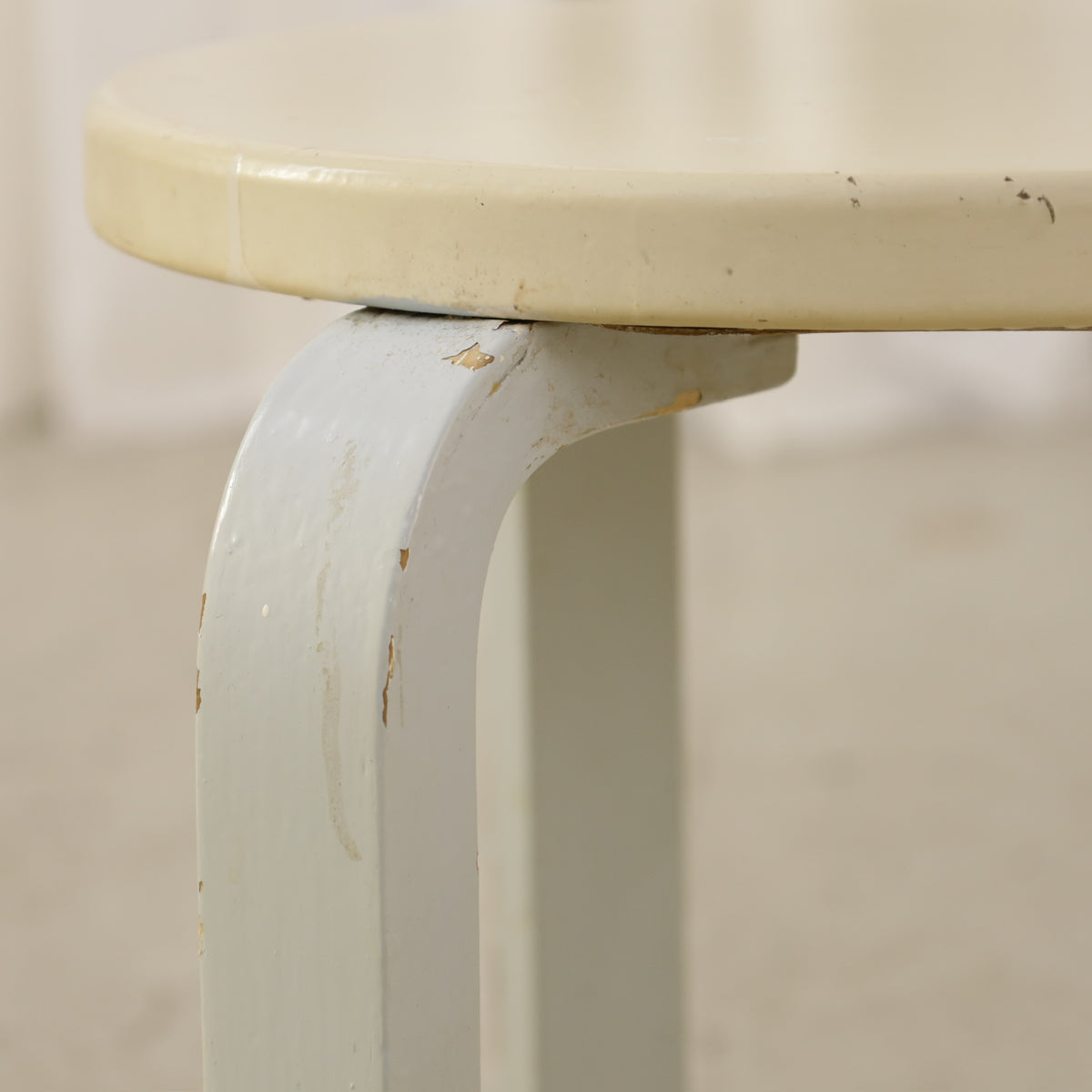 Alvar Aalto Stool 60 for Artek with Light Upholstered Seat, close-up of scuffs on the light seat and painted leg