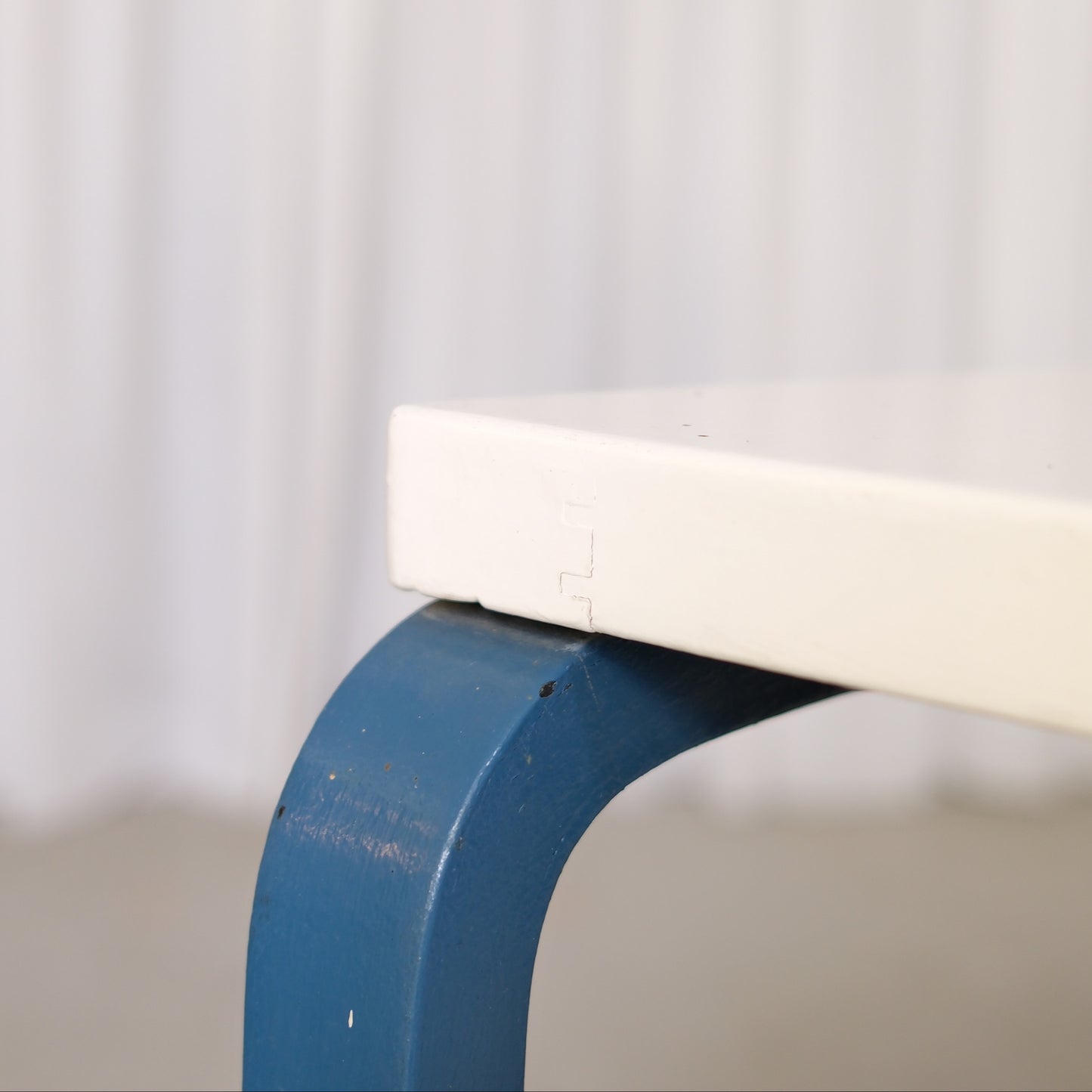 Close-up of paint wear on the white tabletop edge