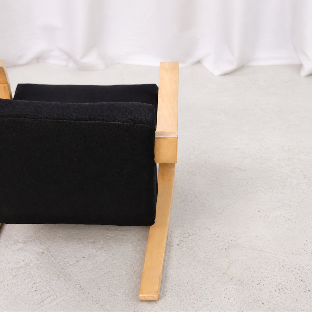 Detail of the birch runner and black upholstery on an Artek 402 armchair