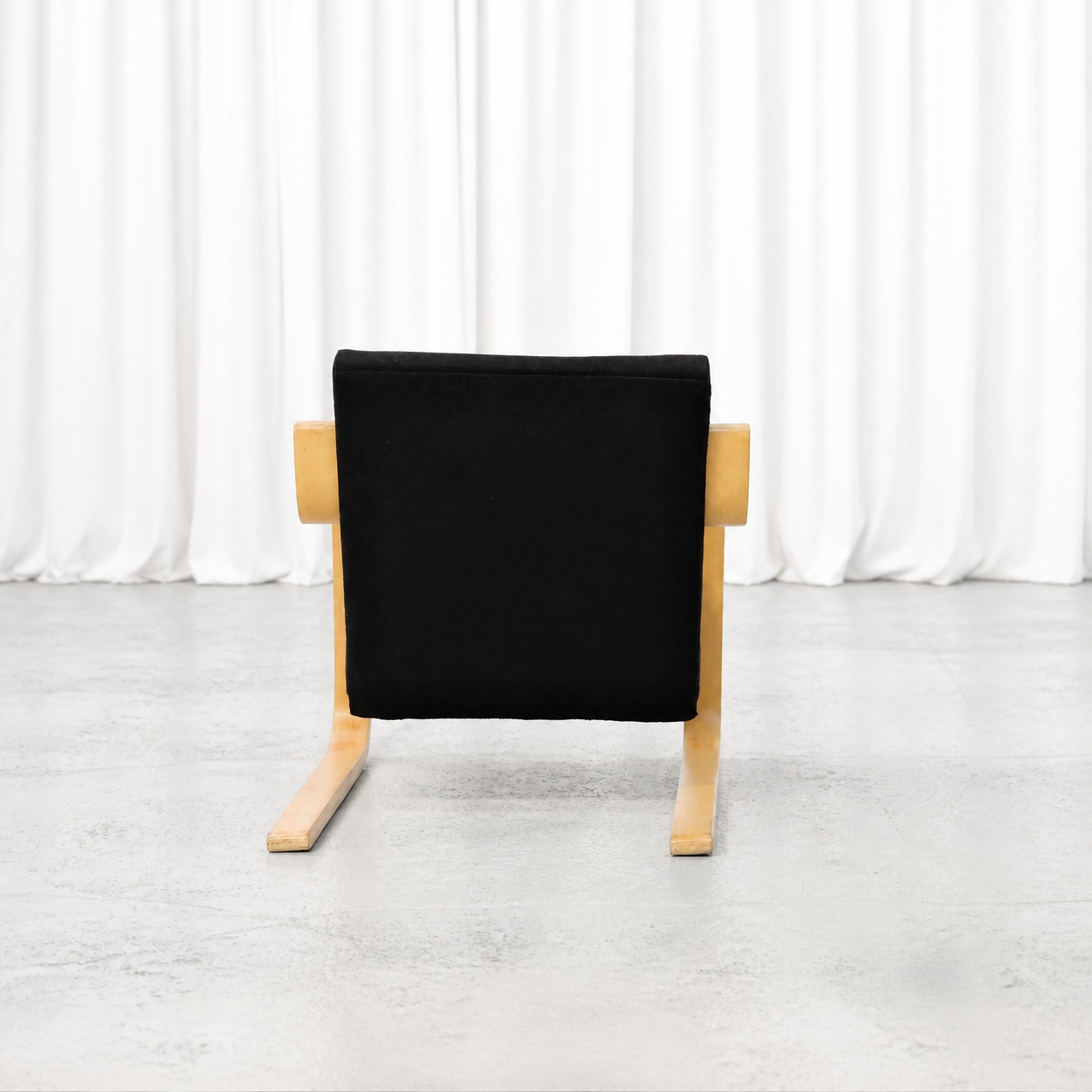 Rear view of the second 1960s Artek 402 armchair with black fabric upholstery
