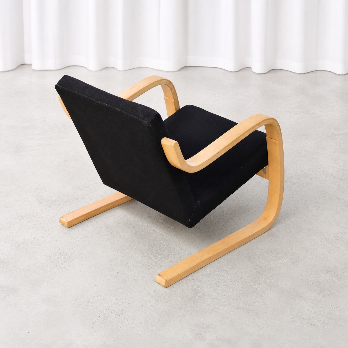 Elevated rear view of an Artek 402 armchair with a bent birch frame