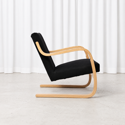Side view of a 1960s Artek 402 armchair with black fabric upholstery