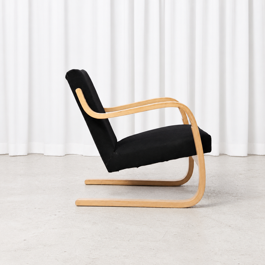 Side view of a 1960s Artek 402 armchair with black fabric upholstery