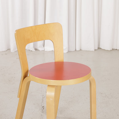 Red linoleum seat and birch backrest of Artek Chair 65