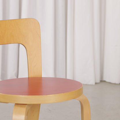 Detail of red linoleum seat surface and birch seat edge