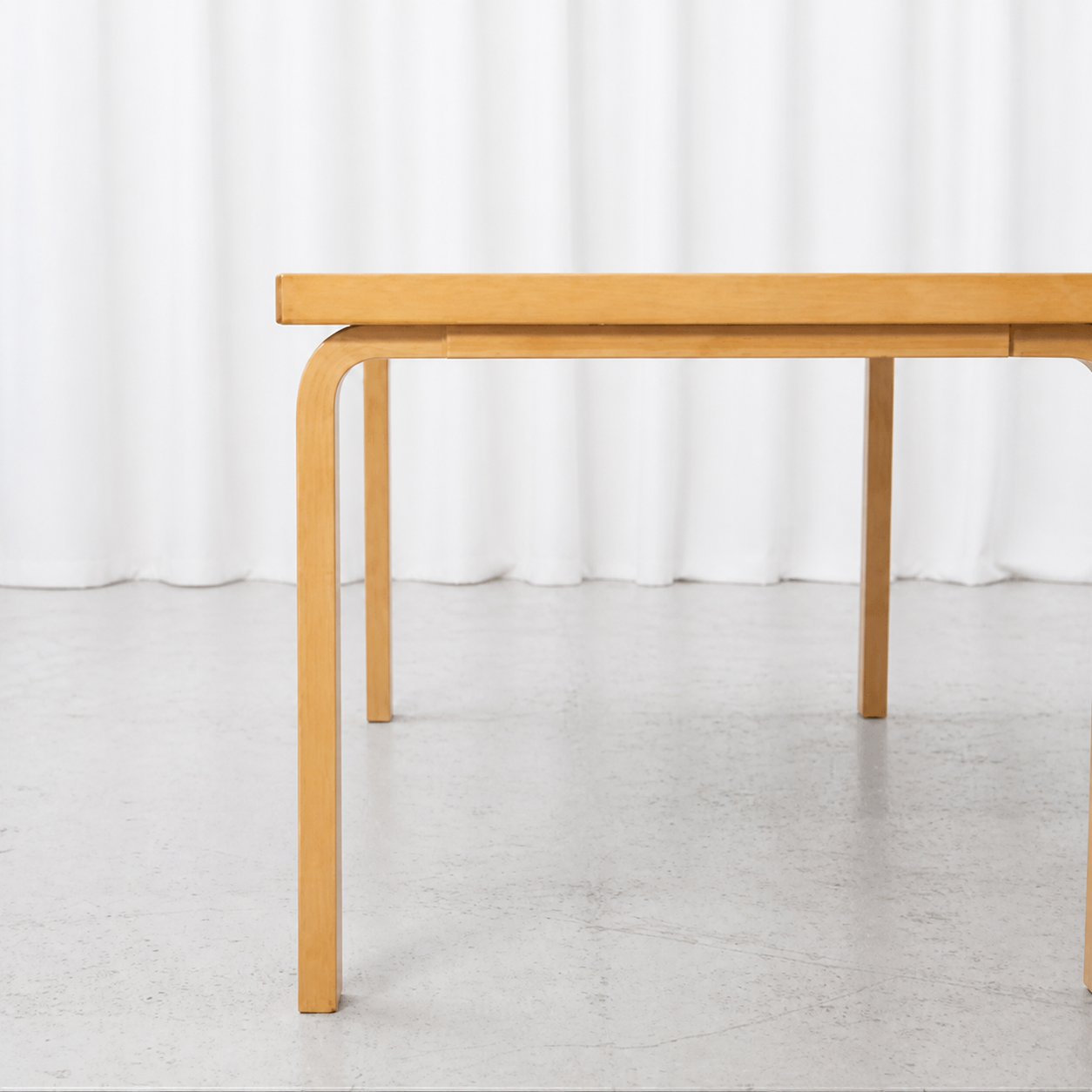Side detail of the birch frame and L-legs on an Artek 82A table