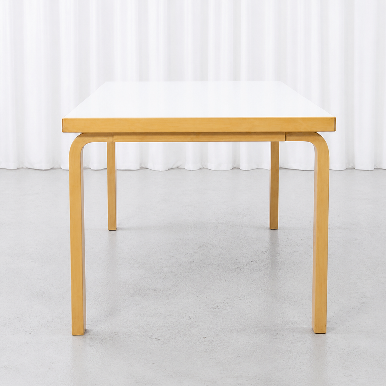Front view of an Artek 82A table with white laminate top