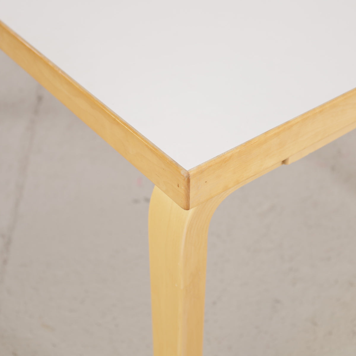 Alvar Aalto 82A table for Artek with white top and birch legs — tabletop edge and birch frame detail