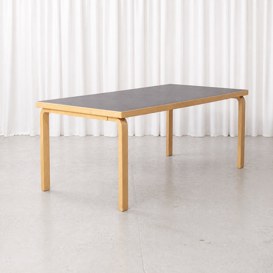 Artek Table 83 in birch with black linoleum top, three-quarter view
