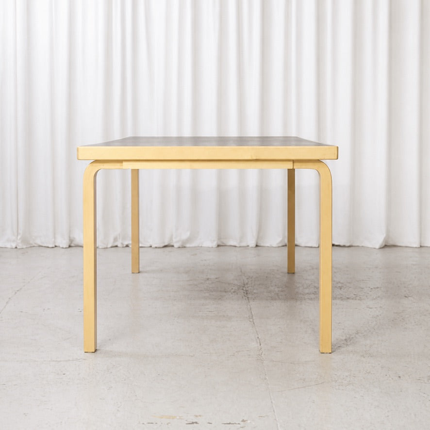 Front view of Artek Table 83 with birch L-legs and black top