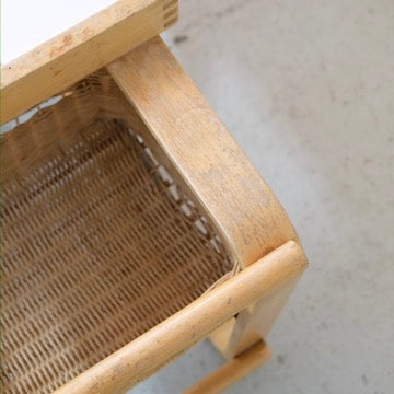Added wooden crossbar beneath the end of the rattan basket