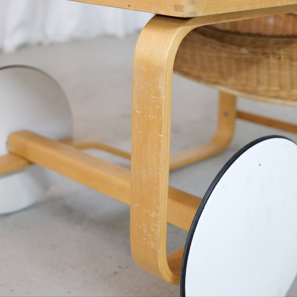 Scratches and wear on the bent birch frame and white wheel