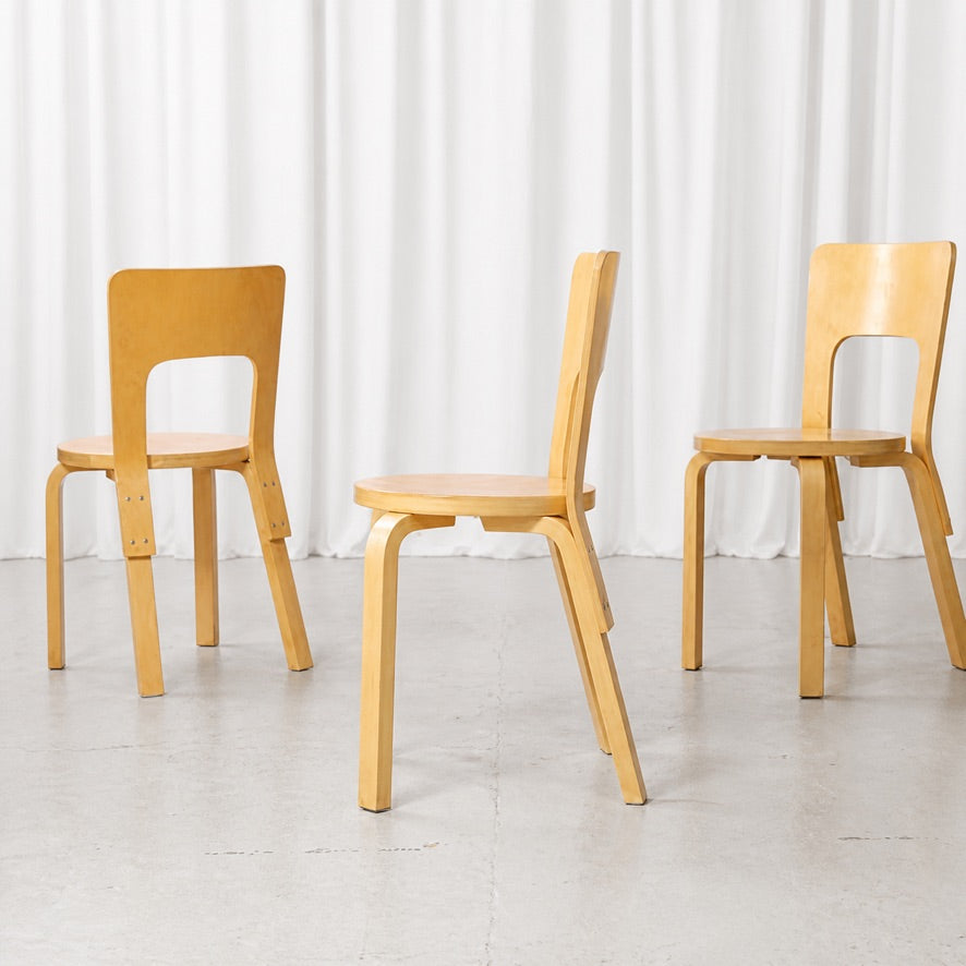Three Artek Chair 66 chairs in birch shown from front, side and rear angles