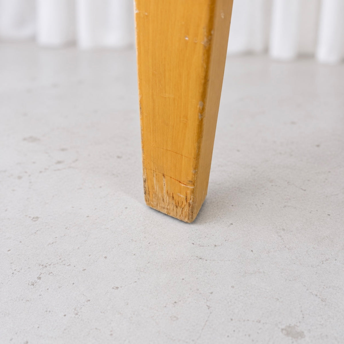 Close-up of wear to the foot of an Artek Chair 66 birch leg