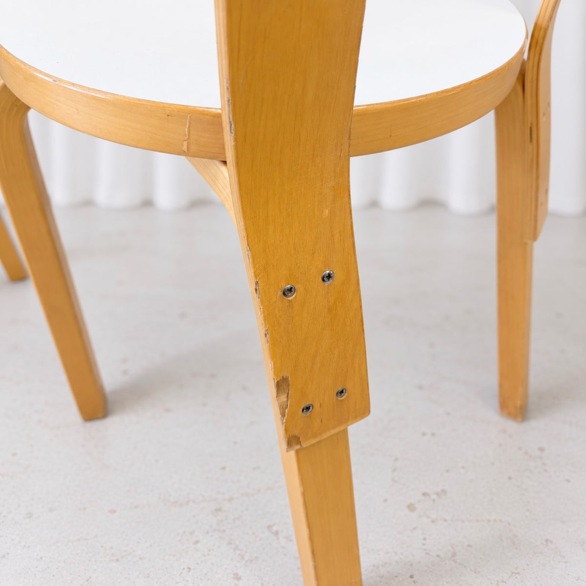 Close-up of veneer loss on the lower backrest support of an Artek Chair 66