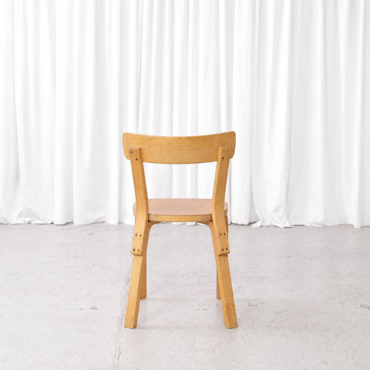 Rear view of a 1950s Artek Chair 69 with finger-jointed L-legs