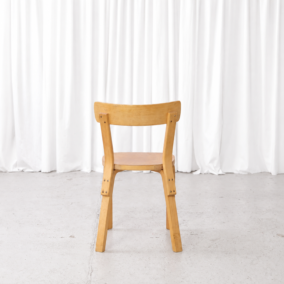 Rear view of a 1950s Artek Chair 69 with finger-jointed L-legs