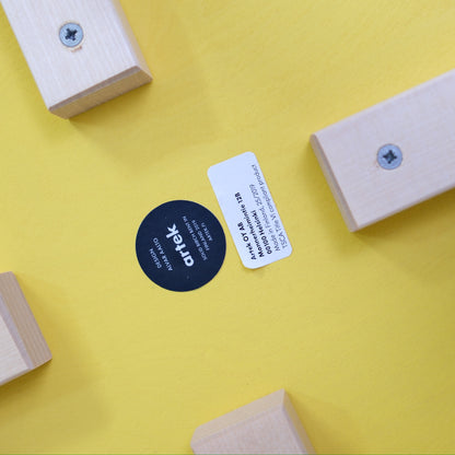 Underside label and four birch leg fixings on the yellow Artek E60 stool