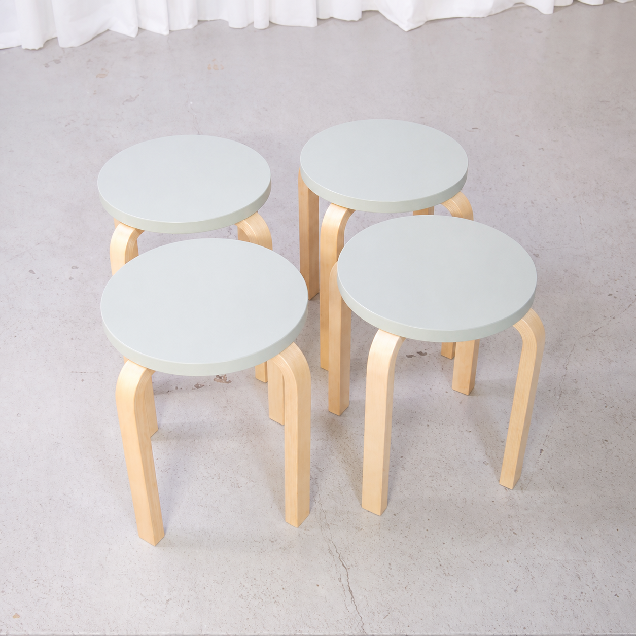 Set of four Artek E60 stools with mint-green seats and natural birch legs
