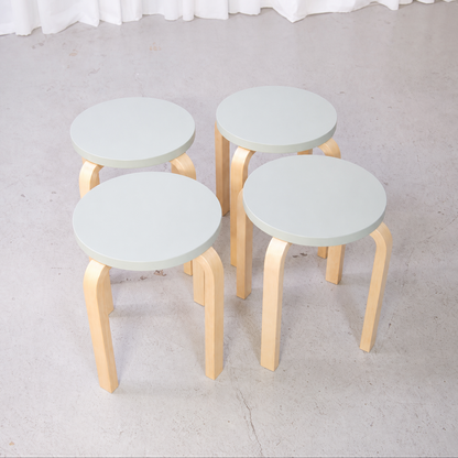Set of four Artek E60 stools with mint-green seats and natural birch legs
