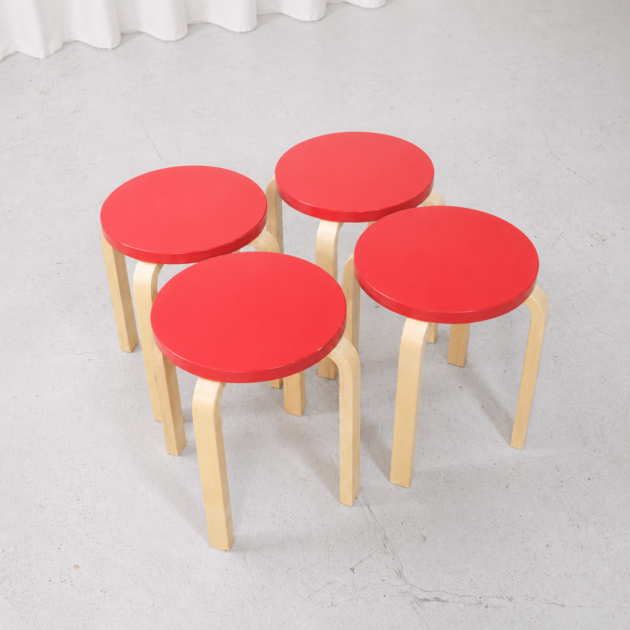 Set of four Artek E60 stools with red lacquered seats
