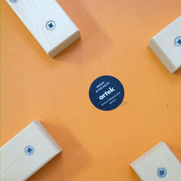 Underside manufacturer label and four birch legs of the 2018 Artek E60 stool