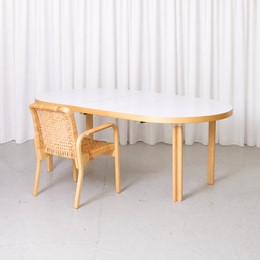 Artek H99 white laminate dining table shown with a birch chair