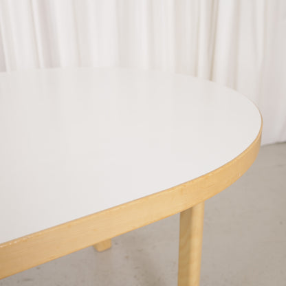 Artek H99 extendable table in white laminate and birch — tabletop edge and sleeve leg detail