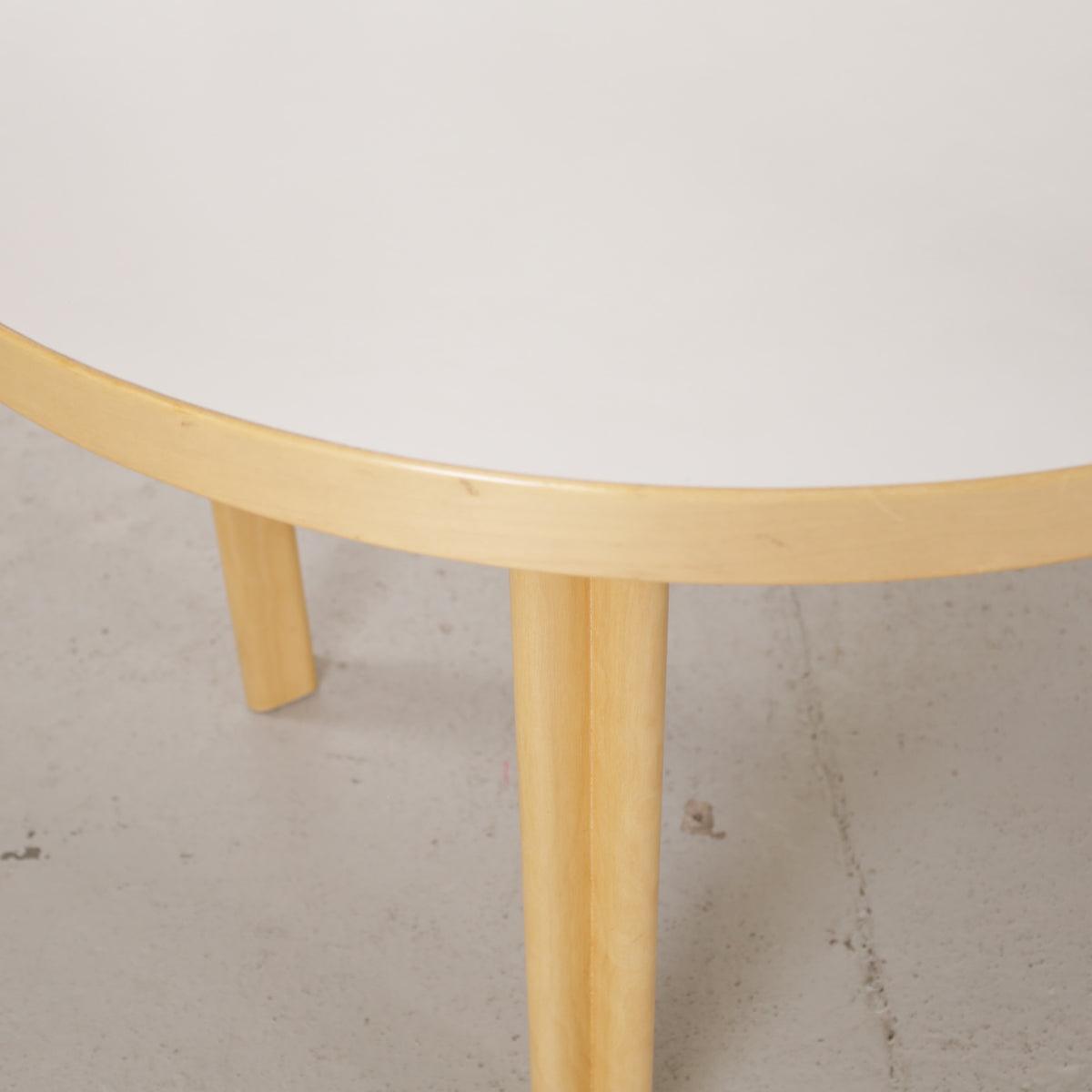 Artek H99 extendable table in white laminate and birch — tabletop edge and sleeve leg detail
