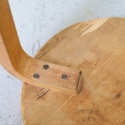 Close-up of an original screw-fixed birch L-leg on Artek Stool 60