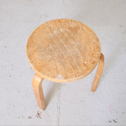 Close top view of heavily worn birch seat on Artek Stool 60