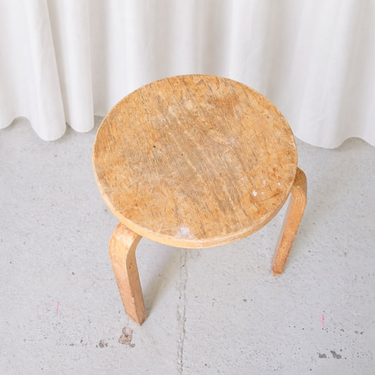 Top view of vintage Artek Stool 60 showing worn birch seat