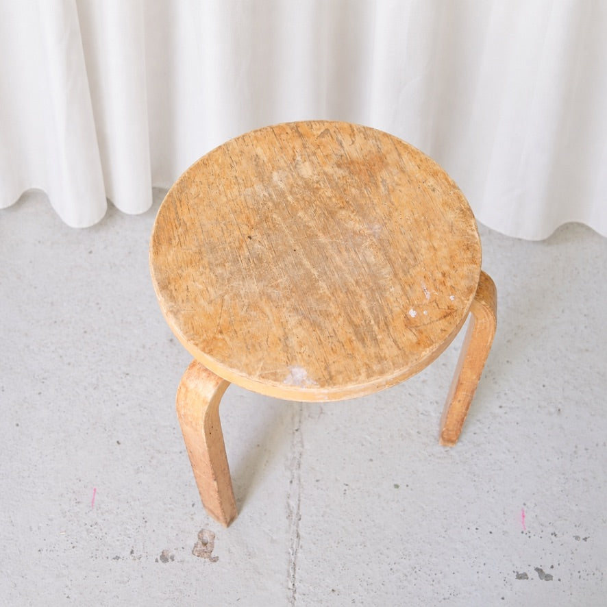 Top view of vintage Artek Stool 60 showing worn birch seat