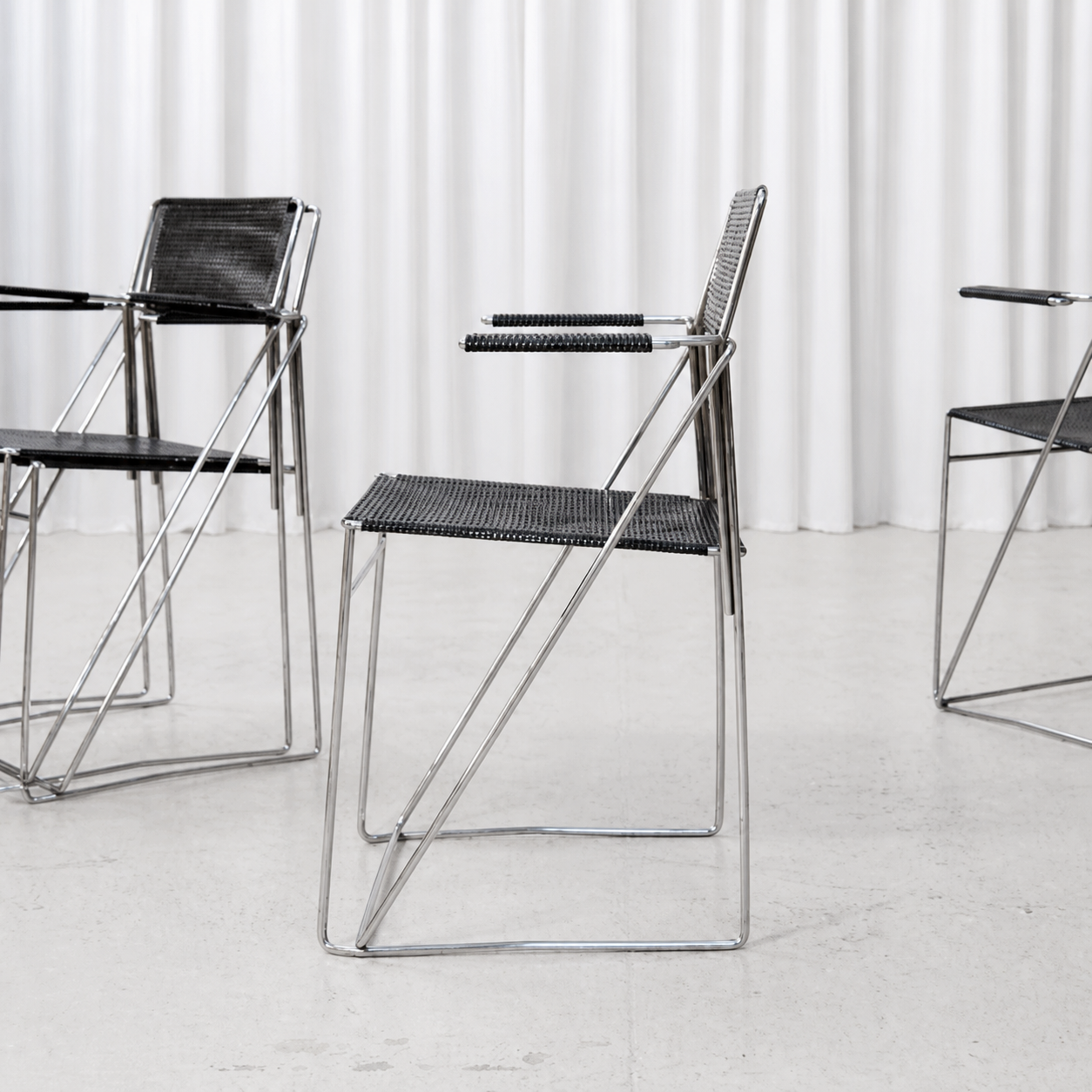 Side view of Hybodan X-Line armchair showing its crossed chrome frame