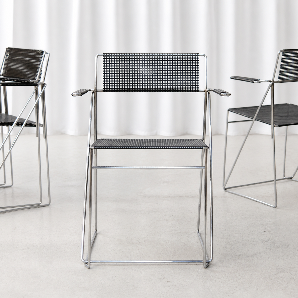 Front view of black and chrome Hybodan X-Line armchair with armrests