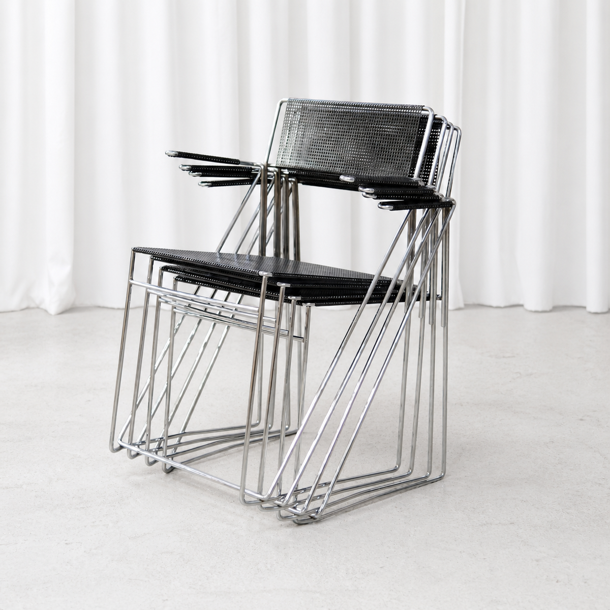Four stackable Hybodan X-Line armchairs nested together