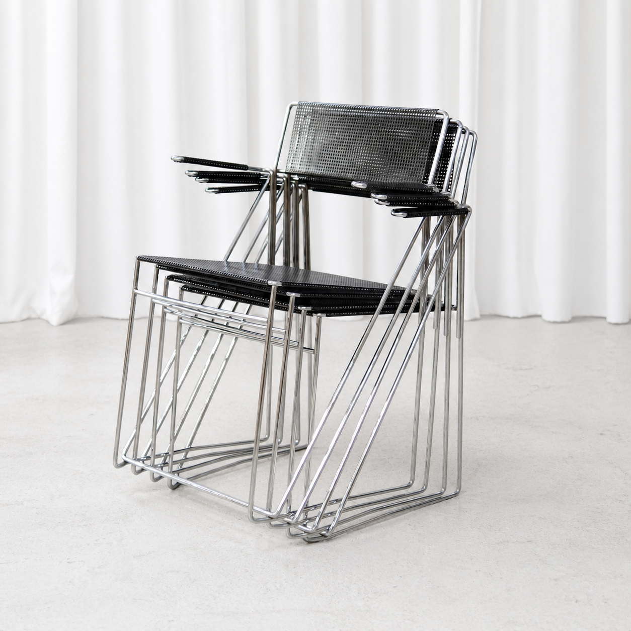 Four stackable Hybodan X-Line armchairs nested together