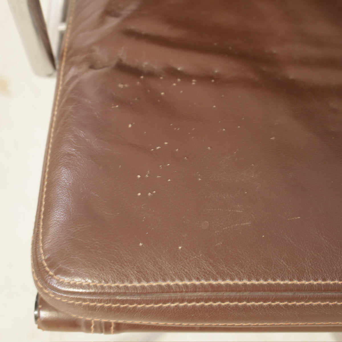 Brown leather seat showing small scratch marks