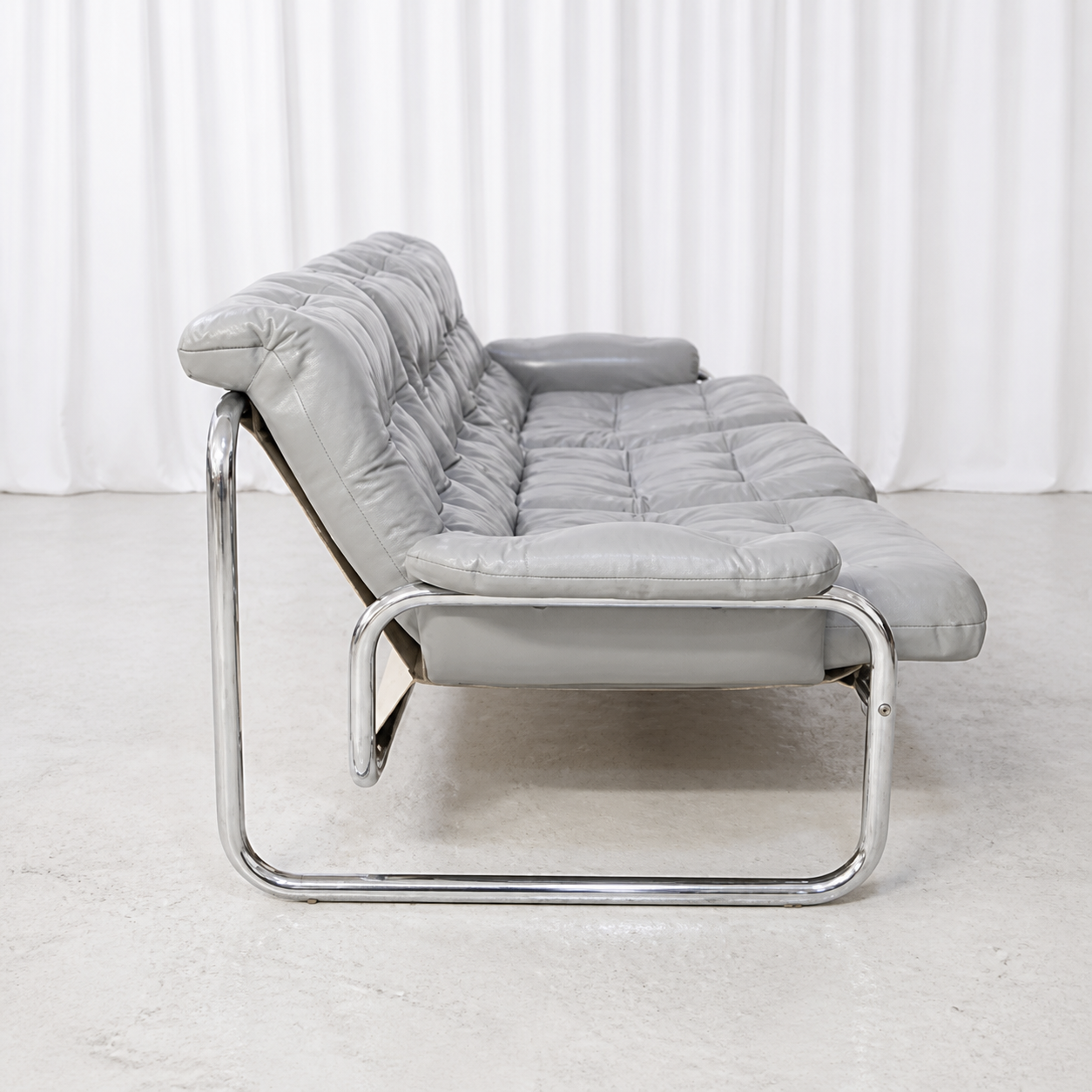 Side view of grey leather IKEA Borkum sofa with chrome tubular base