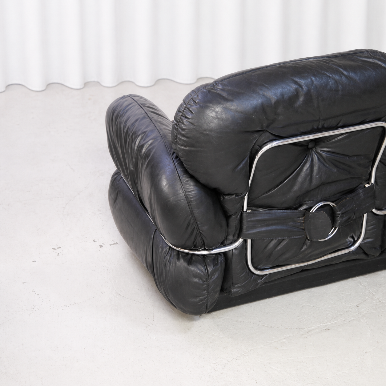 Rear detail of the black leather upholstery and chrome-steel frame of the Isku Hannibal sofa.