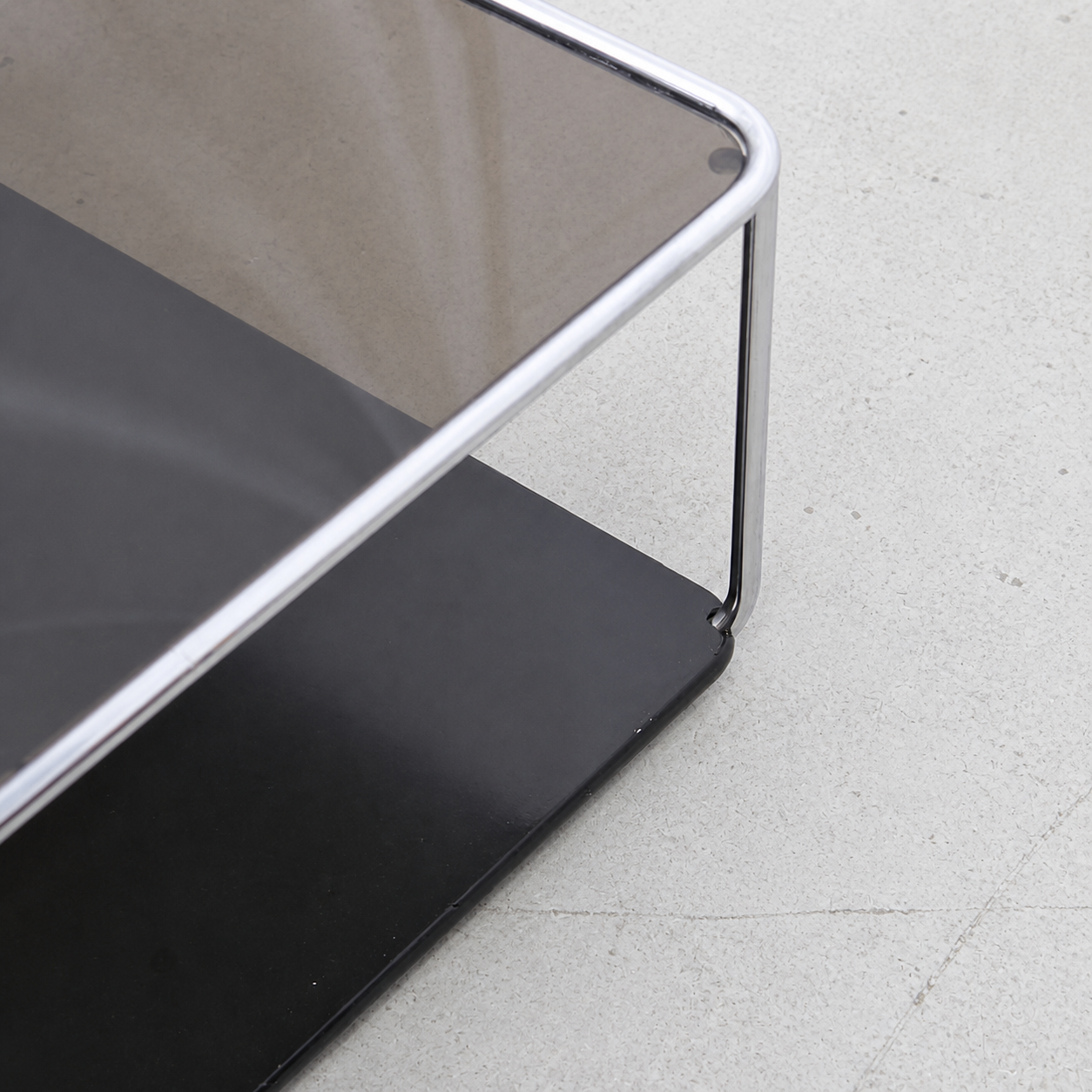 Chrome frame and black lacquered lower shelf corner detail